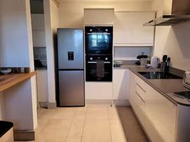 A kitchen with a refrigerator, oven, stove, and counter space at Stunning 6 Bedroom Riverside Barn Cotswold Mill, Ewan near Kemble
