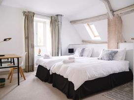 A bedroom with two beds and a desk at Stunning 6 Bedroom Riverside Barn Cotswold Mill, Ewan near Kemble