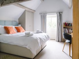 A bedroom with a bed and bookshelf at Stunning 6 Bedroom Riverside Barn Cotswold Mill Ewan near Kemble