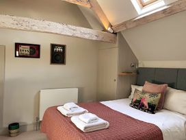 A bedroom with a bed and wall art at Stunning 6 Bedroom Riverside Barn Cotswold Mill Ewan near Kemble