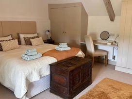 A bedroom with a bed, towels, and a vanity desk at Stunning 6 Bedroom Riverside Barn Cotswold Mill Ewan near Kemble