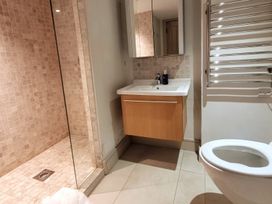 A bathroom with shower, sink, and toilet at Stunning 6 Bedroom Riverside Barn Cotswold Mill Ewan near Kemble