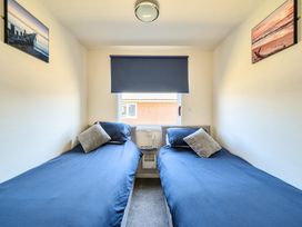 A bedroom with two single beds and wall art at Seahorse Chalet Sleeps 6 Pets Log Burner Beach in Bridlington