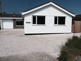 A house with a garage and driveway at Sea Side Stay 6 Pet Friendly Parking Garden Rhosneigr