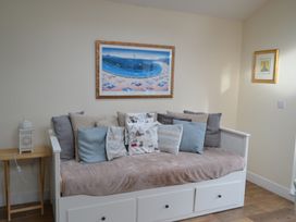 A sitting room with a sofa and decorative cushions at Sea Side Stay 6 Pet Friendly Parking Garden in Rhosneigr