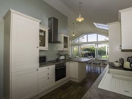 A kitchen with cabinets and appliances at Sea Side Stay 6 Pet Friendly Parking Garden in Rhosneigr
