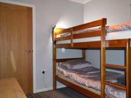 A bedroom with a bunk bed and door at Sea Side Stay 6 Pet Friendly Parking Garden Rhosneigr