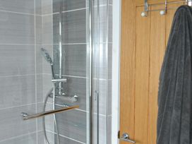 A bathroom with a shower and a towel hanging at Sea Side Stay 6 Pet Friendly Parking Garden in Rhosneigr