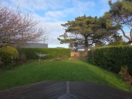 A garden with a tree and clothesline at Sea Side Stay 6 Pet Friendly Parking Garden Rhosneigr