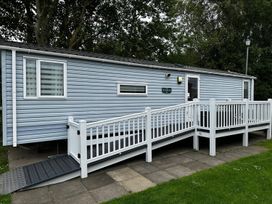 A mobile home with a deck and railings in an outdoor area