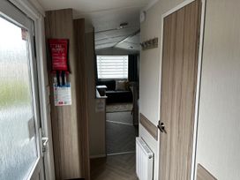 A hallway with a fire blanket, door, and coat hooks at the property in the location