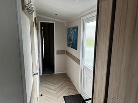 A hallway with a door and a painting at a property
