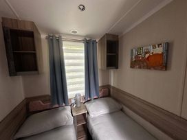 A bedroom with two beds and shelves at 