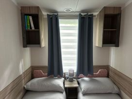 A bedroom with two beds and a shelf at a property