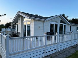 An outdoor area of a cabin with a deck and furniture at Sunset 5 Southview Holiday Park Skegness
