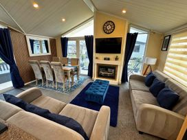 A living room with a sofa and dining table at Sunset 5 Southview Holiday Park Skegness