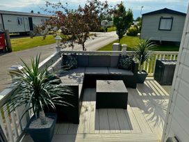 An outdoor seating area with sofa and coffee table at Sunset 5 Southview Holiday Park Skegness