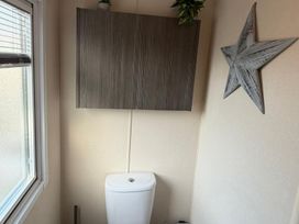 A bathroom with a toilet and a cabinet at 