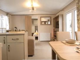 A living room with dining table and television at the property in unspecified location