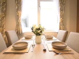 A dining table set with bowls and a flower vase at The Old Barn in Manchester