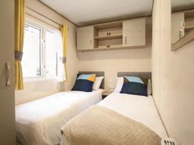 A bedroom with two single beds and shelving at a holiday property in 