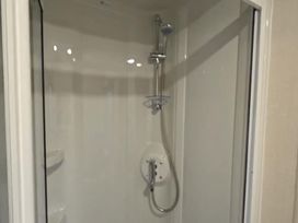 A shower enclosure with a handheld shower and wall-mounted fittings at the property