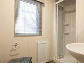 A bathroom with a shower and a sink at the property in location