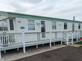 A mobile home with a railing and steps at a holiday park in 
