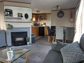 A living room with a kitchen area and furniture at the property