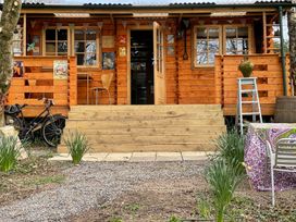 A wooden cabin with stairs and outdoor seating at The Cabin Retreat in Sidmouth