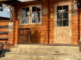 An entrance with stairs, table and chair at a wooden cabin
