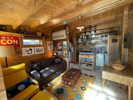A living room with a sofa and kitchen area at the property