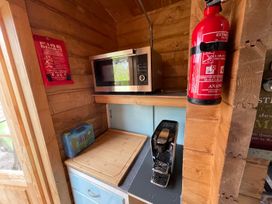 A kitchen with a microwave, coffee machine, and fire safety equipment at the property in 