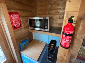 A kitchen corner with a microwave, coffee machine, and fire safety equipment