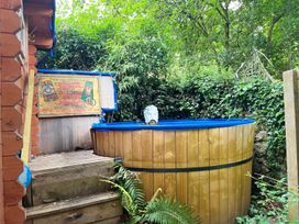A hot tub on a wooden deck in a garden area at the property