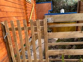 A wooden gate and fence near a log cabin in a garden