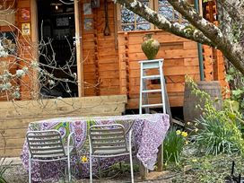 A table with chairs and a vase in front of a wooden cabin