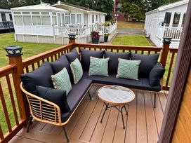 A seating area with a couch and table on a deck at a property