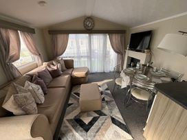 A living room with a sofa and dining set at a holiday home in an unspecified location
