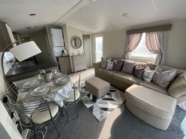 A living room with a dining area and kitchen appliances at the property