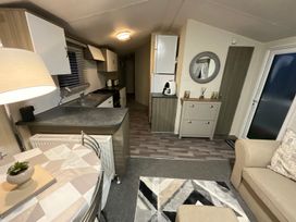 A living room with a kitchen counter and dining table at a holiday home