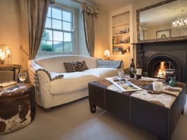 A living room with a fireplace and a coffee table at Three Mile House in Carnforth