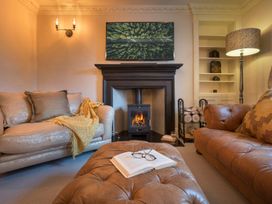 A living room with a fireplace and two sofas at Three Mile House in Carnforth