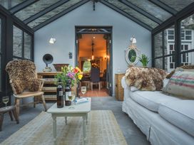 A conservatory with a sofa and coffee table at Three Mile House in Carnforth