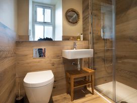 A bathroom with a shower, toilet, and sink at Three Mile House in Carnforth