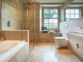 A bathroom with a bathtub, shower, toilet and sink at Three Mile House in Carnforth