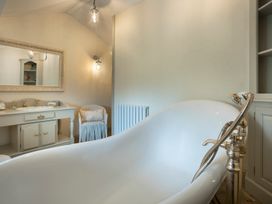 A bathroom with a bathtub, a mirror, and a vanity at Three Mile House in Carnforth