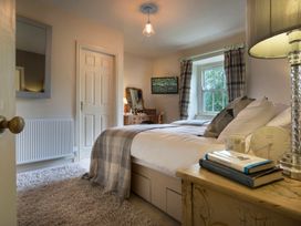 A bedroom with a bed and lamp at Three Mile House in Carnforth