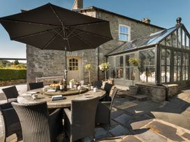 An outdoor dining area with a round table and chairs at Three Mile House in Carnforth