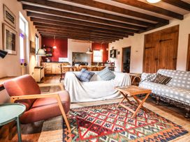 A living room with seating and a kitchen area at Llys Gwaun in Fishguard